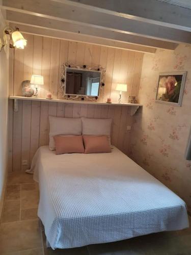 a bedroom with a bed with a tv on the wall at Gite spacieux - 3 chambres - Calme et charmant in Cubnezais