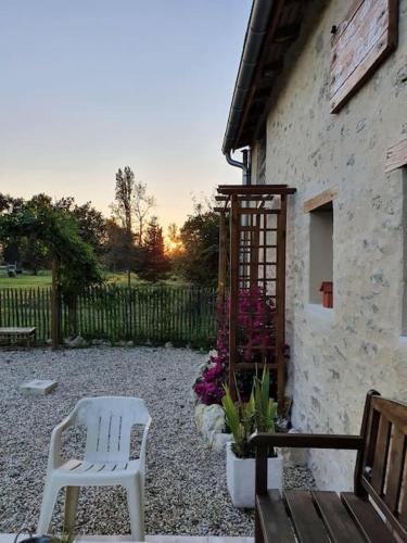 a white chair and a bench next to a building at Gite spacieux - 3 chambres - Calme et charmant in Cubnezais