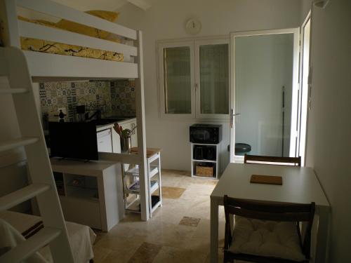 une petite pièce avec une cuisine et une table à manger et un lit superposé dans l'établissement Mazet avec piscine à 6 kms d'Uzes, à Saint-Quentin-la-Poterie