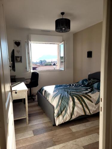 une chambre avec un lit, un bureau et une fenêtre dans l'établissement Charmante Maison GIBISA, au Muy