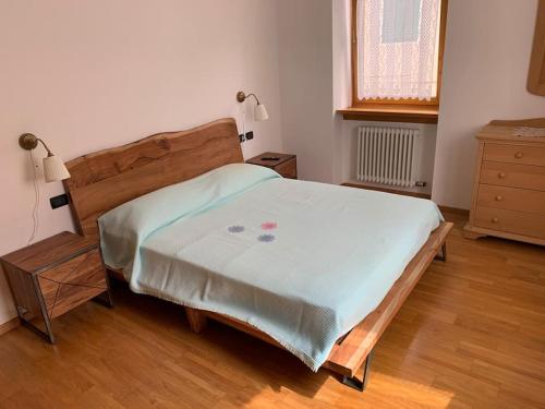a bedroom with a large bed with a wooden headboard at Casa Frasnelli Cunevo in Cunevo