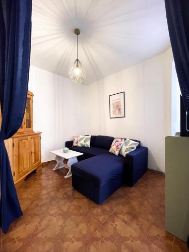 a living room with a blue couch and a table at Climbing House Chèrie Madeleine in Lido Di Fondi
