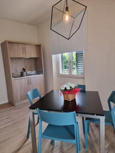 a dining room with a black table and blue chairs at Da Arturo e Maruca suites con 2 camere in Vellano