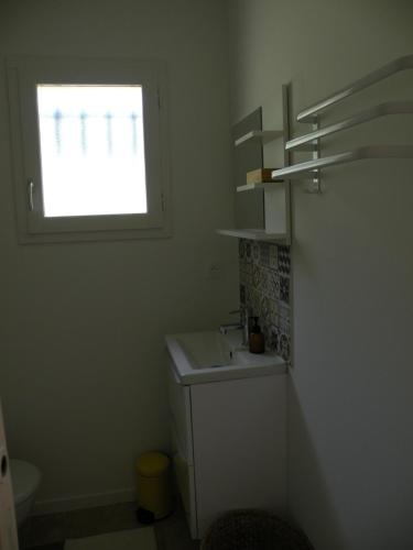 une salle de bain avec un lavabo et une fenêtre dans l'établissement Mazet avec piscine à 6 kms d'Uzes, à Saint-Quentin-la-Poterie