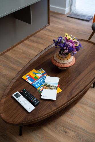a table with a remote control and a vase of flowers at NYX Guesthouse in Tripolis