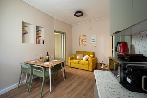 a living room with a table and a yellow couch at NYX Guesthouse in Tripolis
