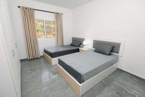 a bedroom with two beds and a window at Chouf View Residence in Baddah