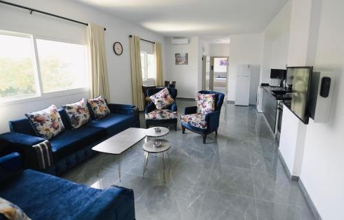 a living room with a blue couch and two chairs at Chouf View Residence in Baddah