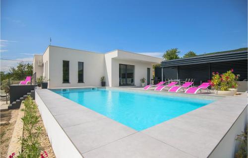einen Pool mit rosa Stühlen neben einem Haus in der Unterkunft Beautiful Home In Glavina Donja in Donja Glavina