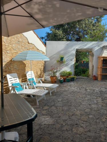a patio with two chairs and an umbrella at Casa Hozani in Albarrol