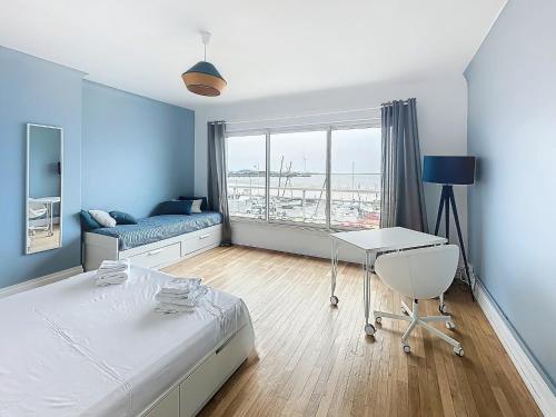 une chambre avec un lit, un bureau et une fenêtre dans l'établissement Le Face Mer, à Boulogne-sur-Mer