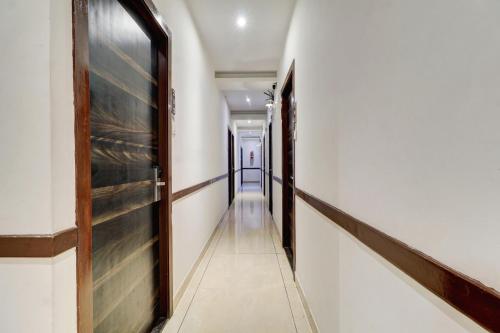 a hallway with white walls and a wooden door at Hotel A. K. International - Fort in Mumbai