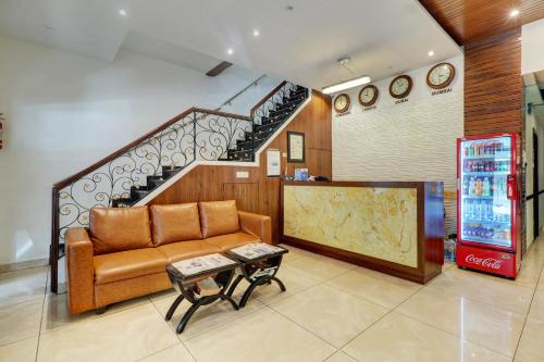 a living room with a couch and a staircase at Hotel A. K. International - Fort in Mumbai