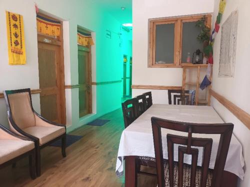 comedor con mesa, sillas y pared verde en Skara Homes, en Leh