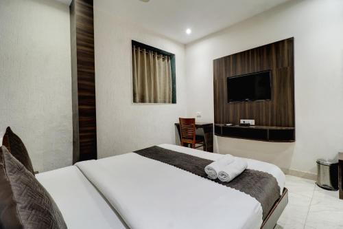 a hotel room with a bed and a television at Hotel A. K. International - Fort in Mumbai