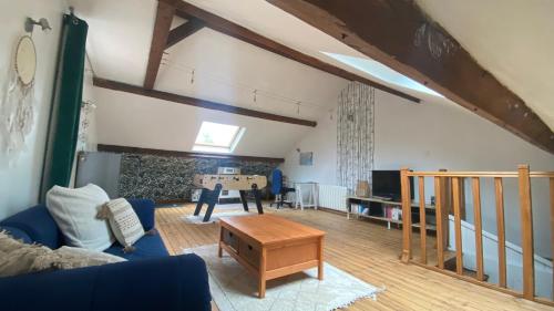 a living room with a blue couch and a table at Les Perdrix in Charleville-Mézières