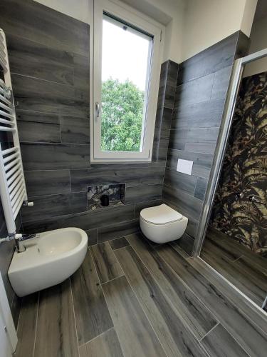 a bathroom with a toilet and a sink and a window at Agriturismo Piccolo paradiso in Pianello Del Lario