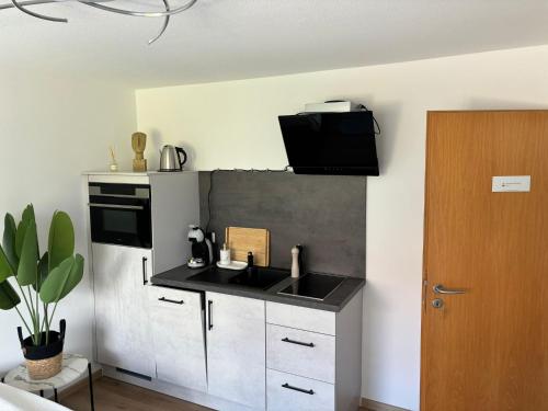 a kitchen with a sink and a microwave at Deluxe Studio Bella in Backnang