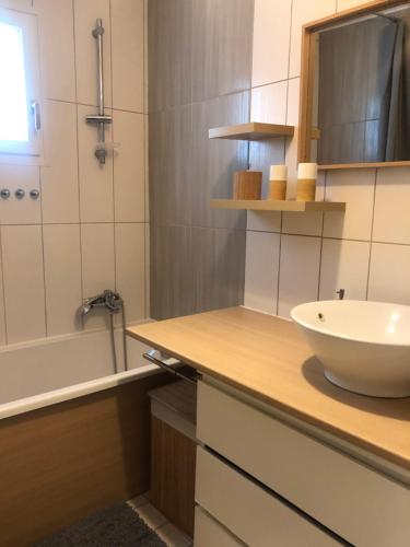 une salle de bain avec un lavabo et une baignoire dans l'établissement maison typique bassin d'Arcachon, au Teich