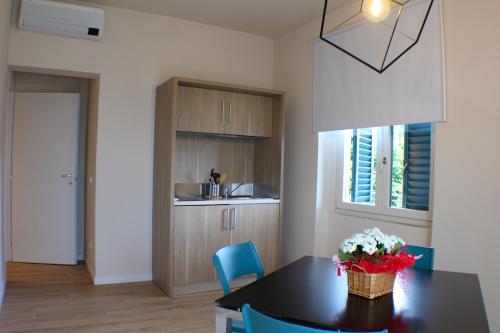 a kitchen with a black table and blue chairs at Da Arturo e Maruca suites con 2 camere in Vellano