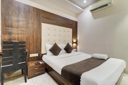 a bedroom with a bed with a wooden wall at Hotel A. K. International - Fort in Mumbai