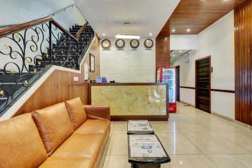 a living room with a couch and a staircase at Hotel A. K. International - Fort in Mumbai