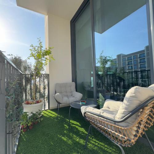 a patio with two chairs on a balcony at Marassi Beach Residence Bahrain in Rayyā