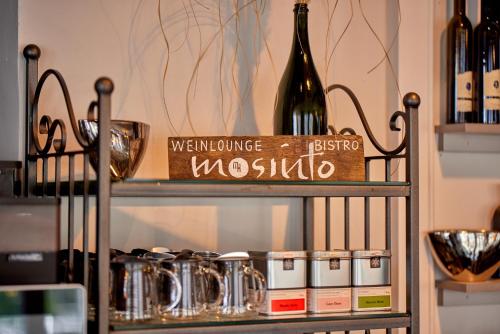 a shelf with a bottle of wine and some bottles at Moselhotel Römischer Kaiser in Bernkastel-Kues
