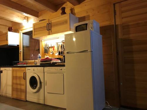 une cuisine avec un réfrigérateur et une machine à laver dans l'établissement chalet le daguet en Cévennes, à Camprieu