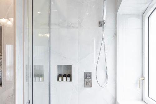 a bathroom with a shower with a glass door at CARLTON COURT - MAYFAIR in London