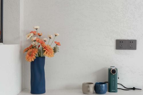 a blue vase with flowers in it on a table at 夕下青野民宿 The Setting Sun in Qiantan