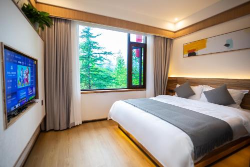 une chambre avec un grand lit et une grande fenêtre dans l'établissement A Mountain Home别有洞天-山居民宿, à Taiping