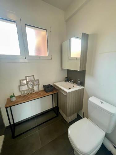 une salle de bain avec des toilettes blanches et un lavabo dans l'établissement Le Verlaine, studio en centre ville à deux minutes des plages, à Menton
