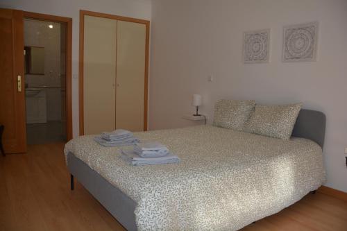 a bedroom with a bed with towels on it at Albergue Santa Justa in Moura