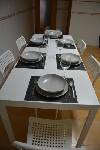 a white table with plates and wine glasses on it at Albergue Santa Justa in Moura
