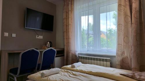 a hotel room with a bed and a window at Jaworina- Apartamenty, Domki i Pokoje in Solina