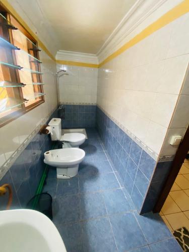 a bathroom with two toilets and a sink at Chambres d'hôtes Beluga in Nosy Be