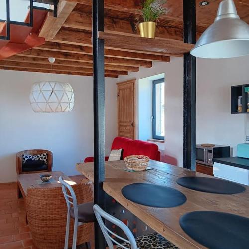 un salon avec une table et des chaises en bois dans l'établissement Maison d'artistes avec cour au cœur du vignoble, à Saint-Gengoux-de-Scissé