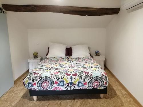 une chambre avec un lit avec une couette colorée dans l'établissement Maison d'artistes avec cour au cœur du vignoble, à Saint-Gengoux-de-Scissé