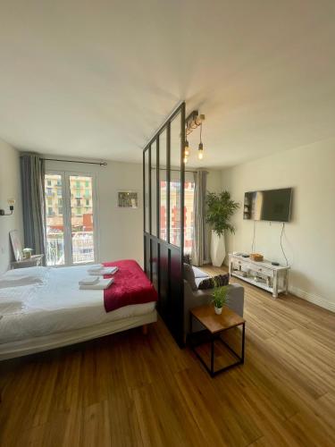 - une chambre avec un grand lit et une télévision dans l'établissement Le Verlaine, studio en centre ville à deux minutes des plages, à Menton