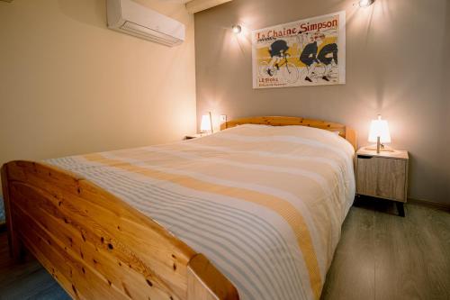 - une chambre avec un grand lit en bois et 2 lampes dans l'établissement Centre historique et bord du tarn - clim - unique, à Albi