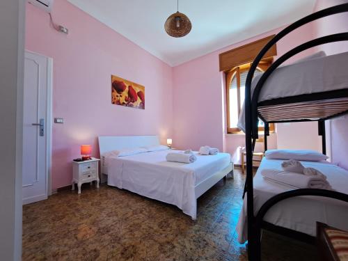 two beds in a room with pink walls at Villa Mele in Lido Marini