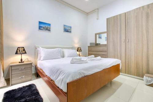 a bedroom with a large bed with white sheets at NR Retreat in Il-Gżira