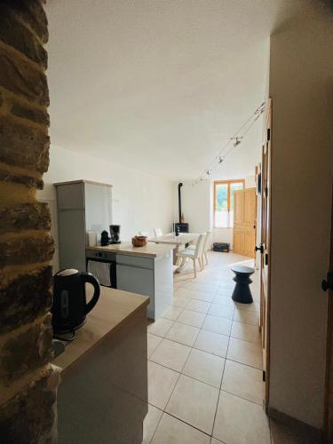 une cuisine avec des appareils blancs et une table dans une pièce dans l'établissement La Maison Cosy, à Frontenay