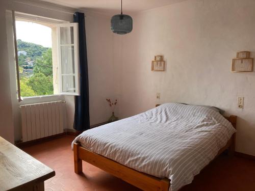 a bedroom with a bed and a window at Chez la Mamé in Alès