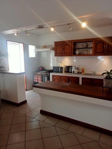 a kitchen with wooden cabinets and a counter top at Villa en résidence proche de l'aéroport in Ambohibao