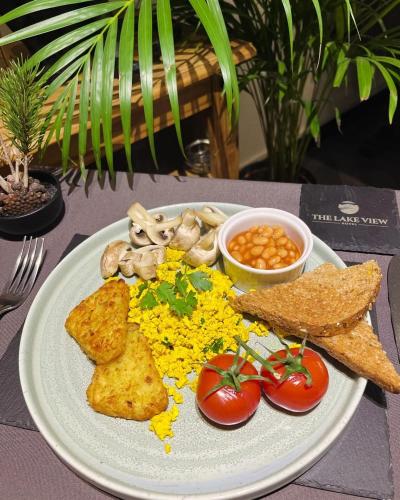 a plate of food with tomatoes and toast and mushrooms at The Lake View Hotel in Llanberis