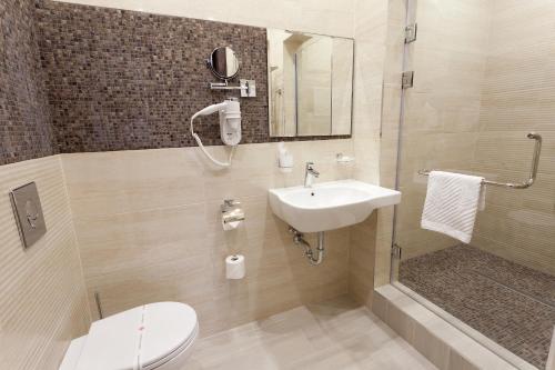 La salle de bains est pourvue de toilettes, d'un lavabo et d'une douche. dans l'établissement Chocolatier Hotel, à Krasnodar