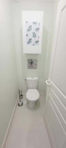 une salle de bain avec toilettes et un tableau au mur dans l'établissement L'ombrelle, à Mimizan