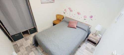 une petite chambre avec un lit et une télévision dans l'établissement L'ombrelle, à Mimizan